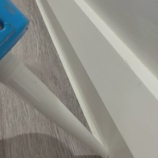 Running a bead of Supreme Sealants sanitary silicone along a skirting board with a caulking gun