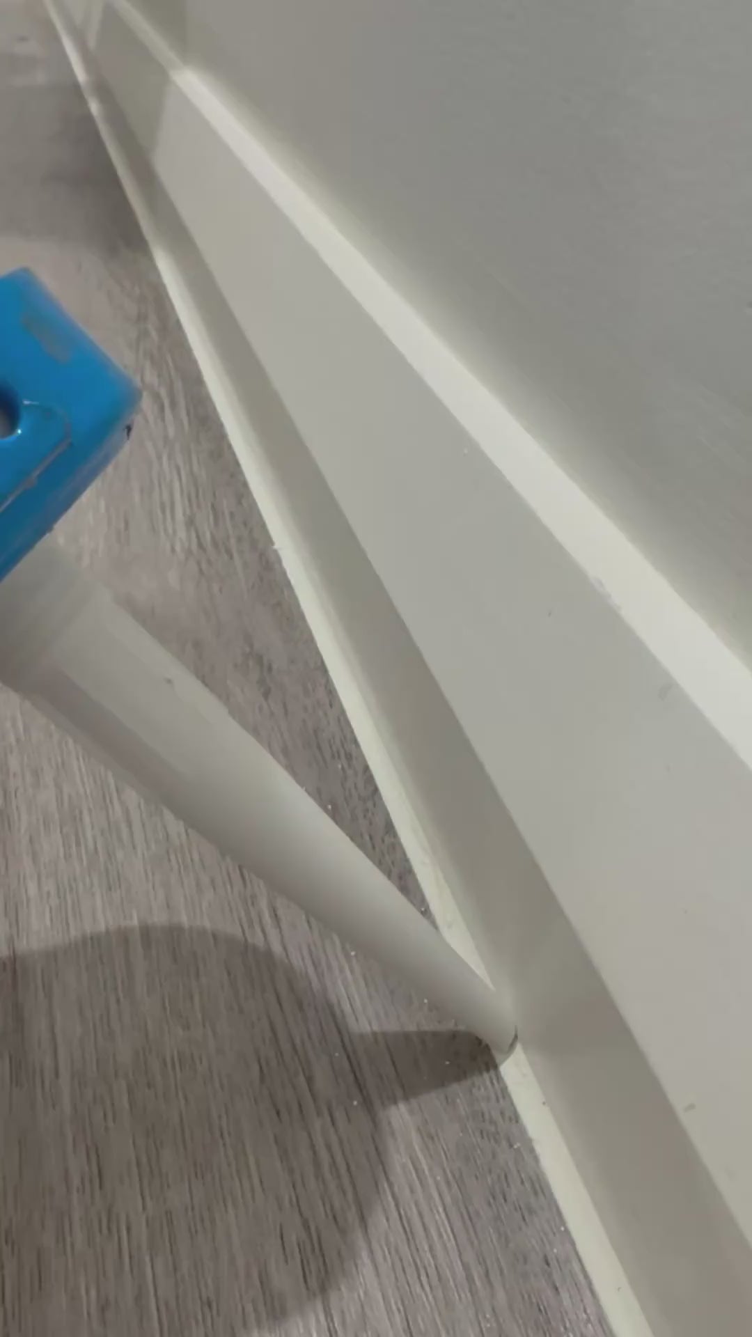 Running a bead of Supreme Sealants sanitary silicone along a skirting board with a caulking gun